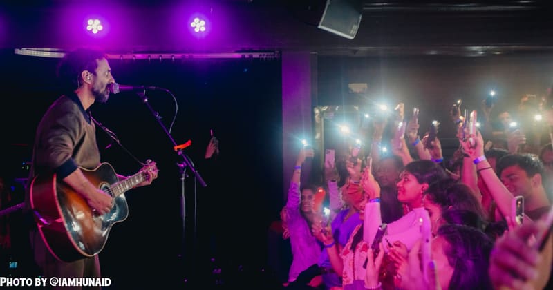 The crowd holding up phone lights for the band