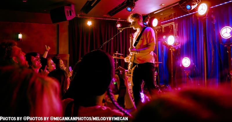 The crowd in front of a band on a red-lit stage